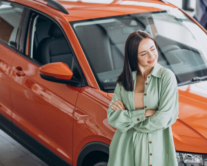 Woman contemplating her finance options, leaning against a new car