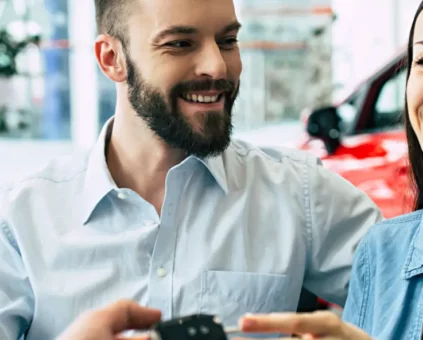 Happy couple accepting the keys to their newly financed car