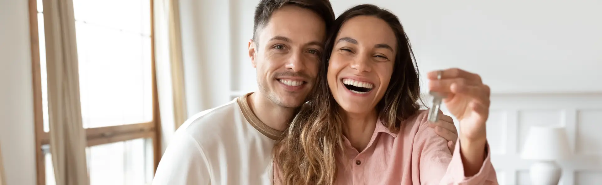 Happy couple holding the keys to their first home