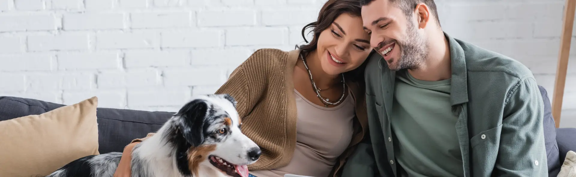 Happy young couple smiling with pet dog