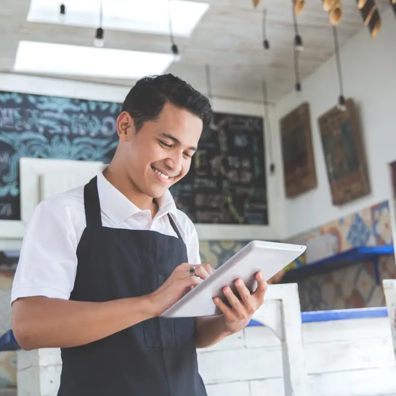 Happy male waiter taking order