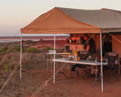 Camper trailer set up behind 4WD at sunset