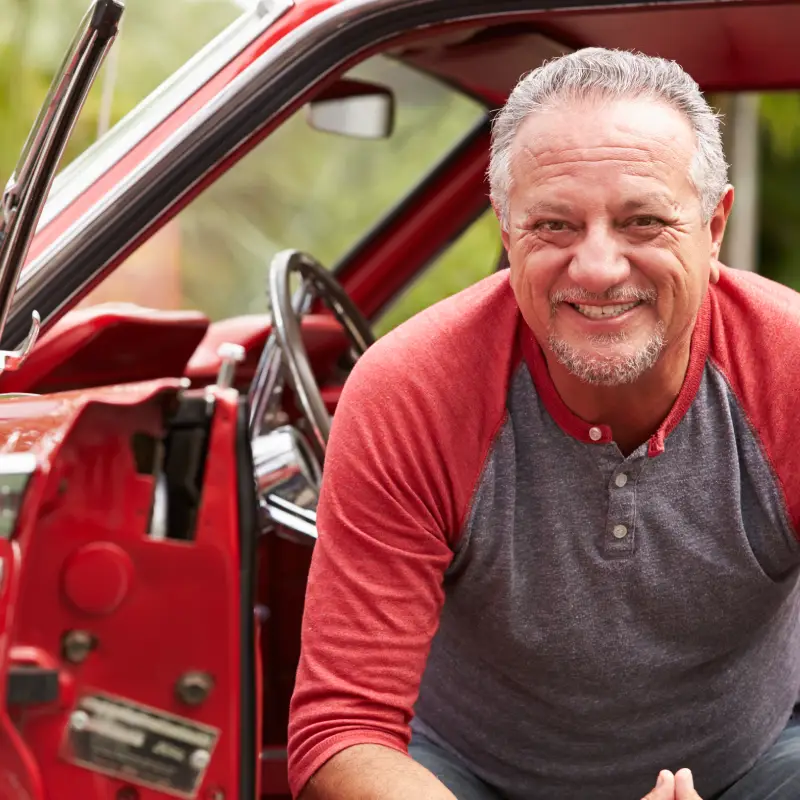 Happy Middle aged male client with financed classic car