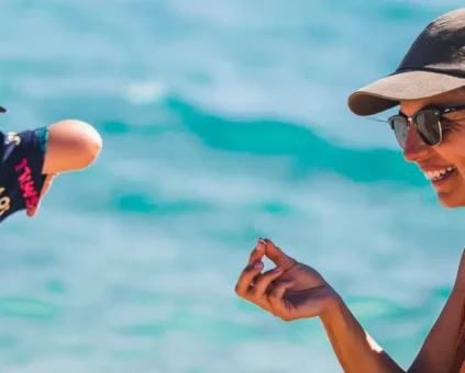 Mum and son playing on the beach with shells