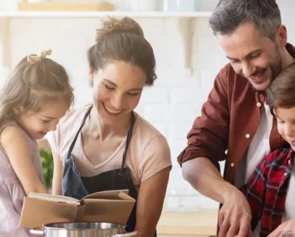 Mother, father, daughter and son cooking together as a family in the kitchen