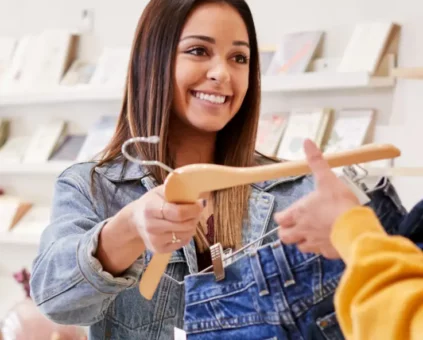 Shop assistant handing clothes to a customer in a retail store