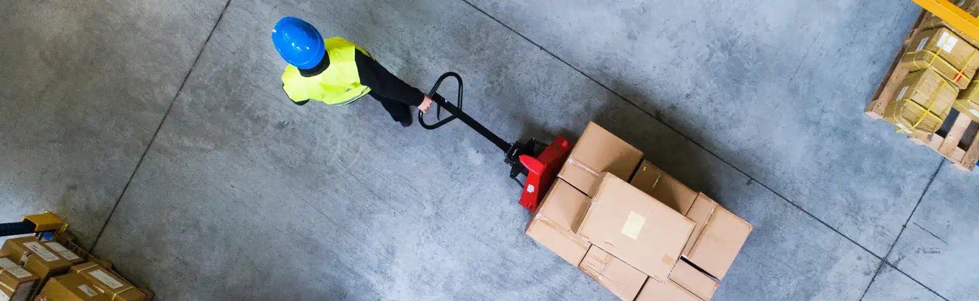 Person Transporting Pallet with Boxes in Warehouse