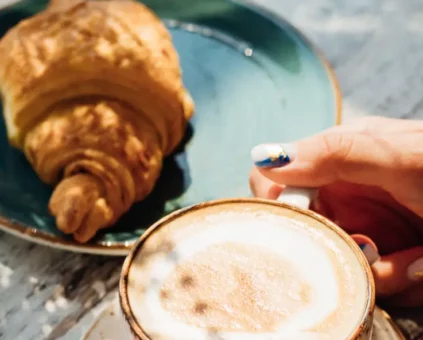 Croissant placed next to coffee