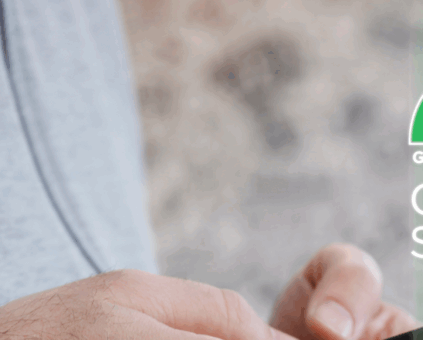 Close-up of a person using a smartphone, with focus on their hands and wrist wearing a leather bracelet. Overlaid on the right side of the image is a colorful credit score gauge ranging from "GOOD" (green) to "POOR" (red), with a needle pointing toward the middle. The words "CREDIT SCORE" are displayed beneath the gauge, suggesting the person is checking or managing their credit score via a mobile app.