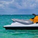 White and orange jet ski sitting in the water after getting finance