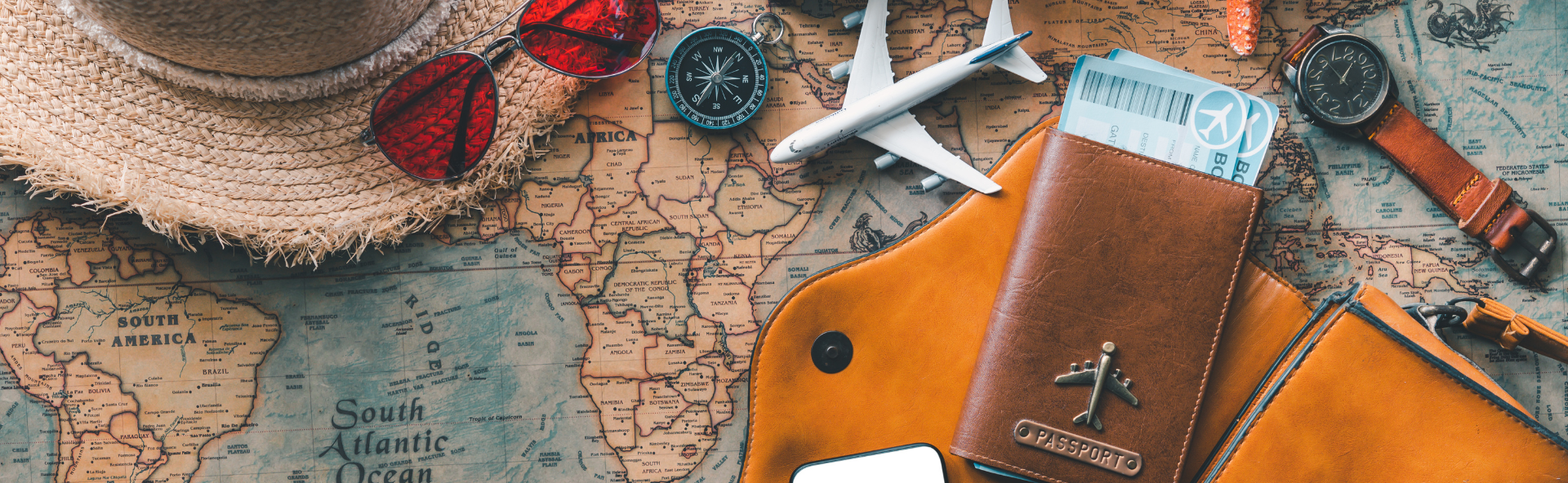 Travel essentials including passport, plane model, and smartphone on world map, representing personal loan funding for vacation and travel expenses