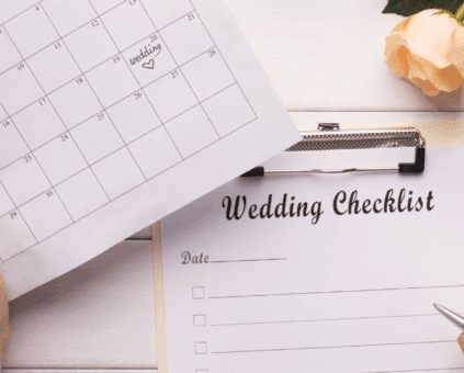 Person planning a wedding using a checklist and calendar beside a laptop and coffee, symbolising how personal loans can help organize and finance wedding expenses