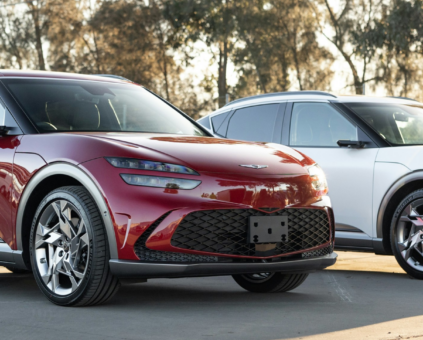 Two Genesis GV60 electric SUVs in red and white parked at an Australian dealership, representing EV finance options available through Fox Finance Group.