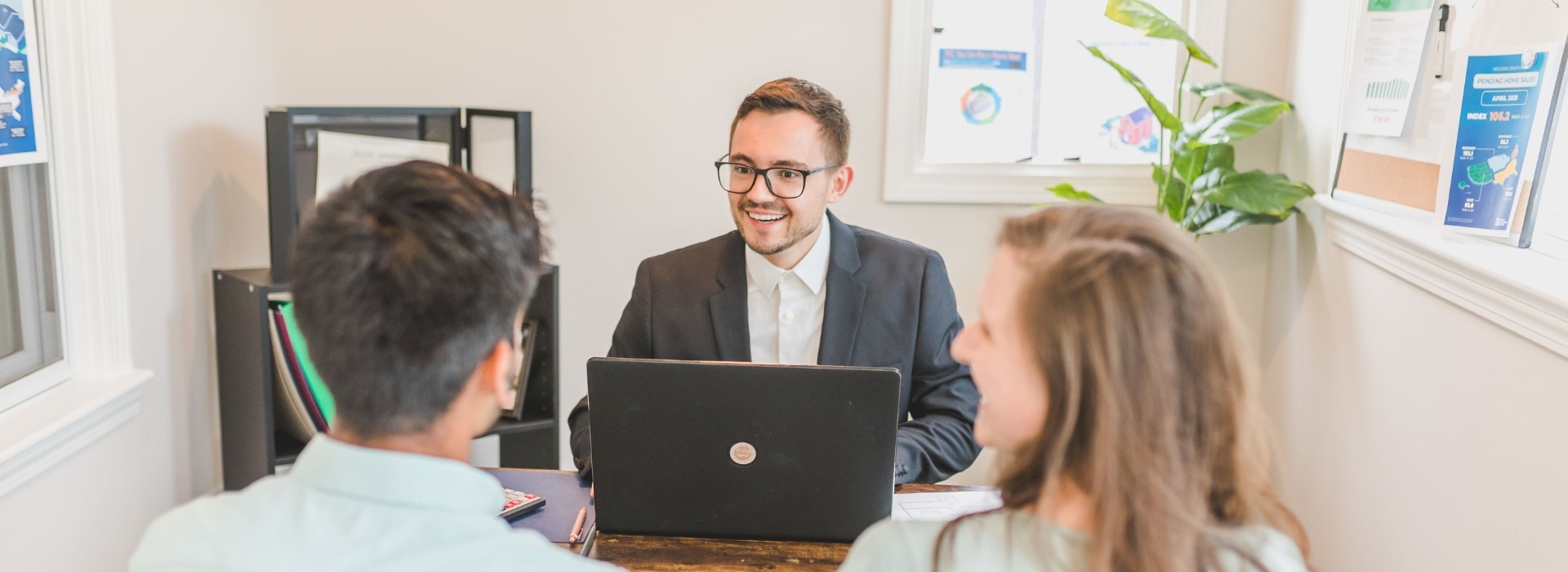 couple sitting with a Fox Finance Group lending specialist, looking relaxed while reviewing car finance options on a laptop