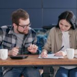 Person comparing various finance options. including advertised car loan rates and their higher comparison rate that includes fees