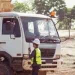 An Owner-operator standing beside a work truck on a worksite, Australia.