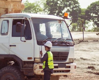 An Owner-operator standing beside a work truck on a worksite, Australia.