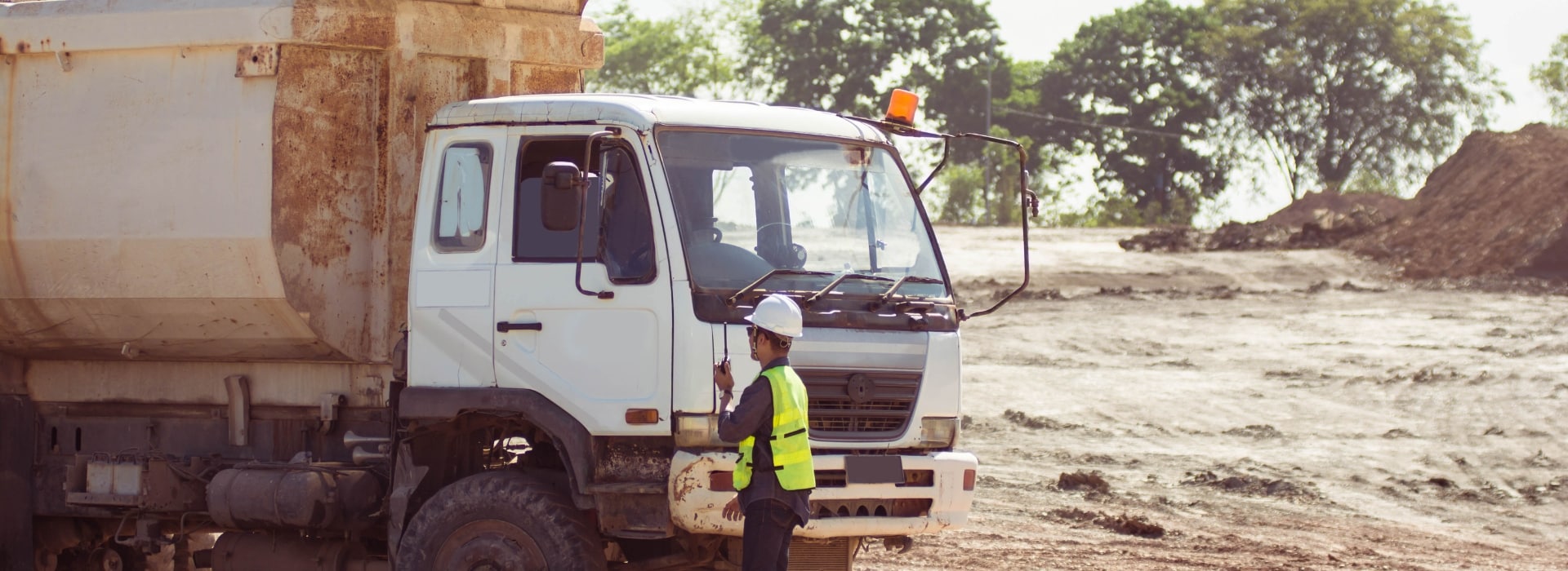 An Owner-operator standing beside a work truck on a worksite, Australia.