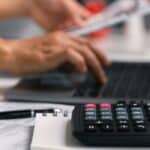 Australian small business owner reviewing bank statements and invoices at their own counter