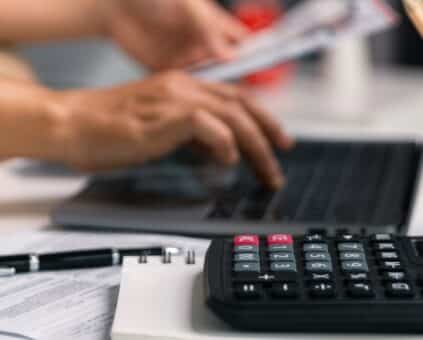 Australian small business owner reviewing bank statements and invoices at their own counter