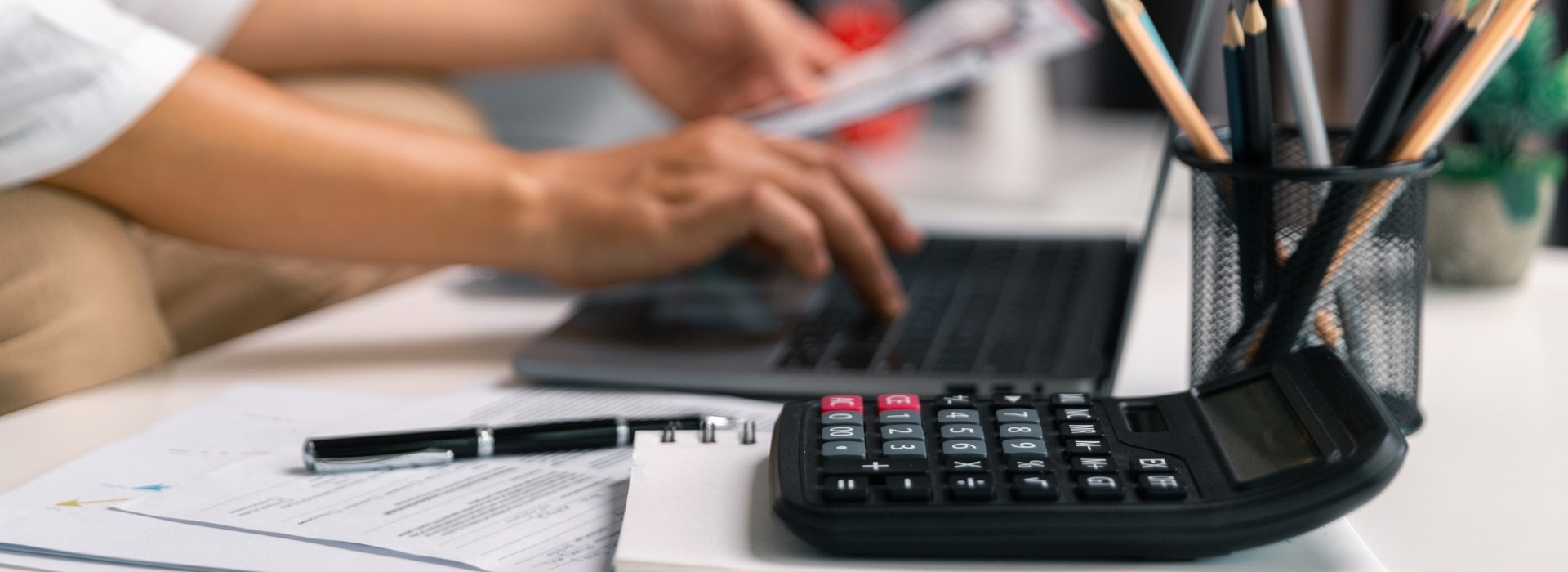 Australian small business owner reviewing bank statements and invoices at their own counter