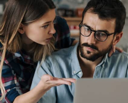 Couple reviewing bills on a laptop